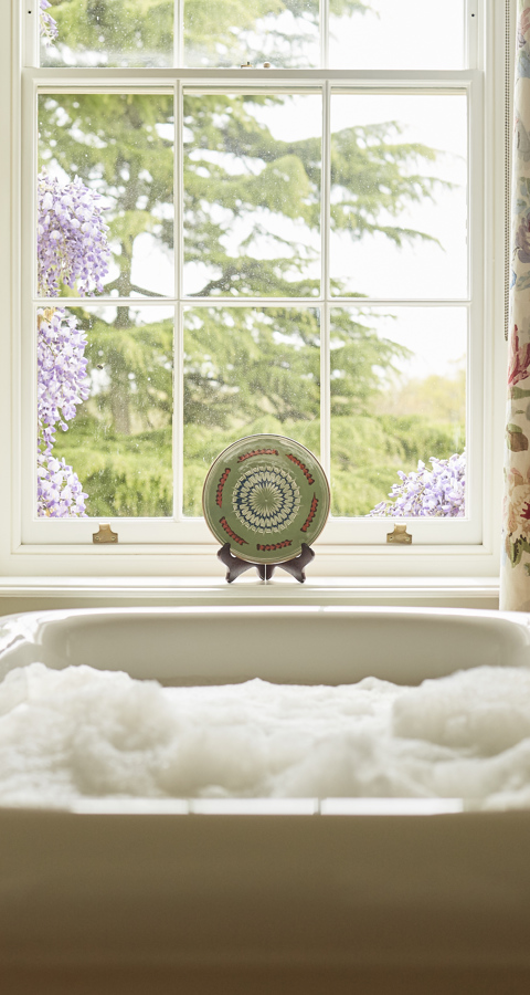 A bath full of bubbles in front of a window